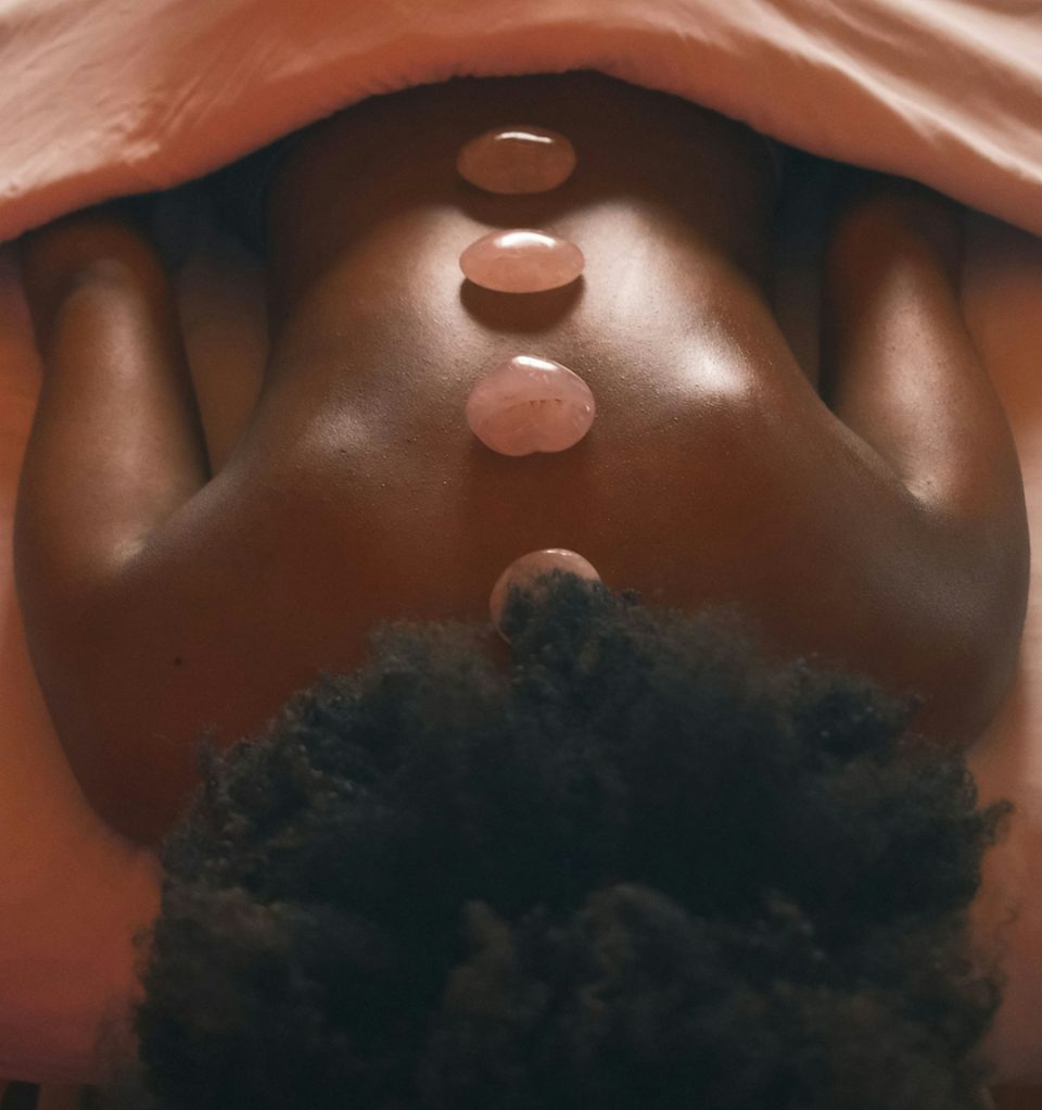 a woman laying on top of a bed under a blanket